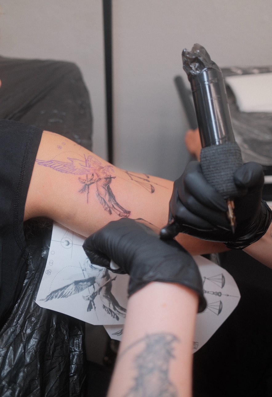 Professional tattoo artist creating custom tattoo design at Le Krib studio